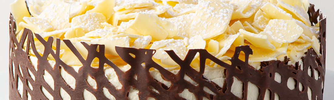 Chocolate-decorated cake with white chocolate shavings.