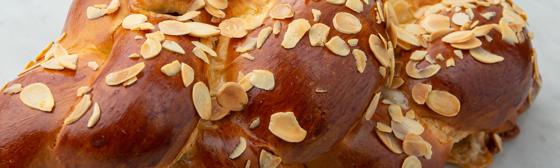 Braided bread topped with sliced almonds.